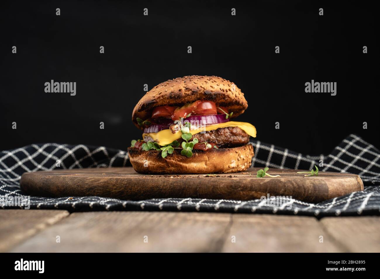 Studio shot of ready-to-eat hamburger with red bell pepper, onions and cheese Stock Photo