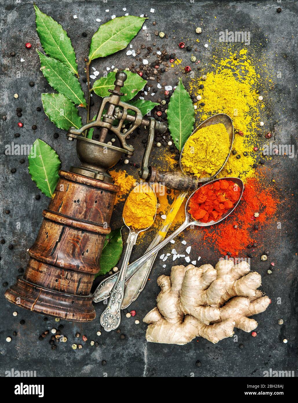 Food background. Spices and old pepper mill. Curry, turmeric, ginger, bay leaf, paprika powder