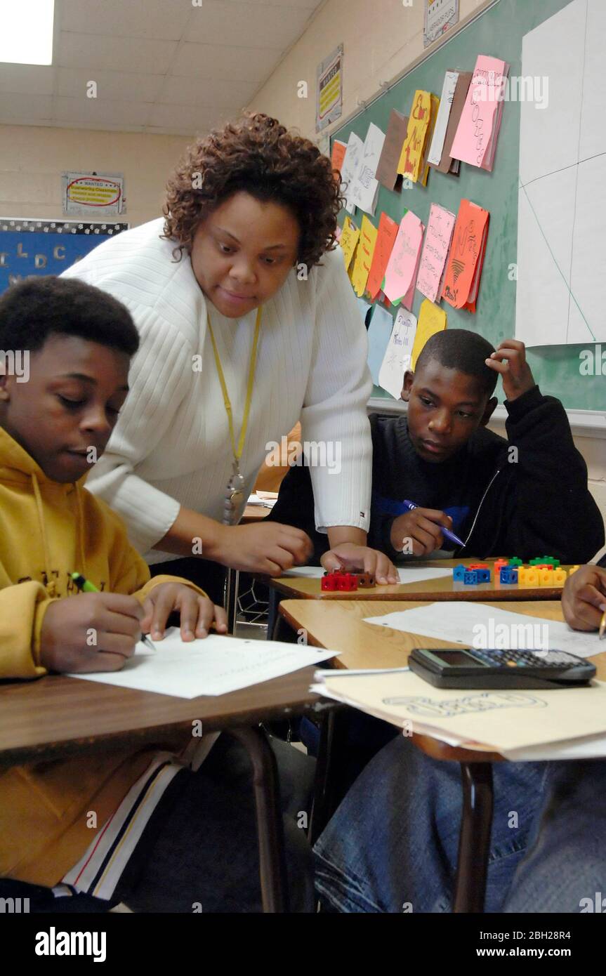 Fort Worth, Texas USA, December 1, 2006.  Teacher works with ninth grade math students  on probability problems in a class at Dunbar High School.  ©Bob Daemmrich Stock Photo