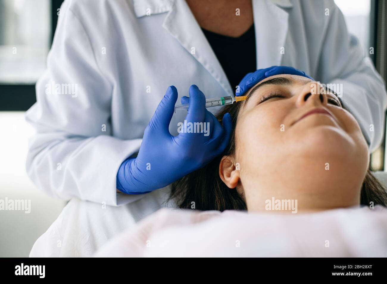 Woman receiving hyaluronic acid injection in medical practice Stock Photo