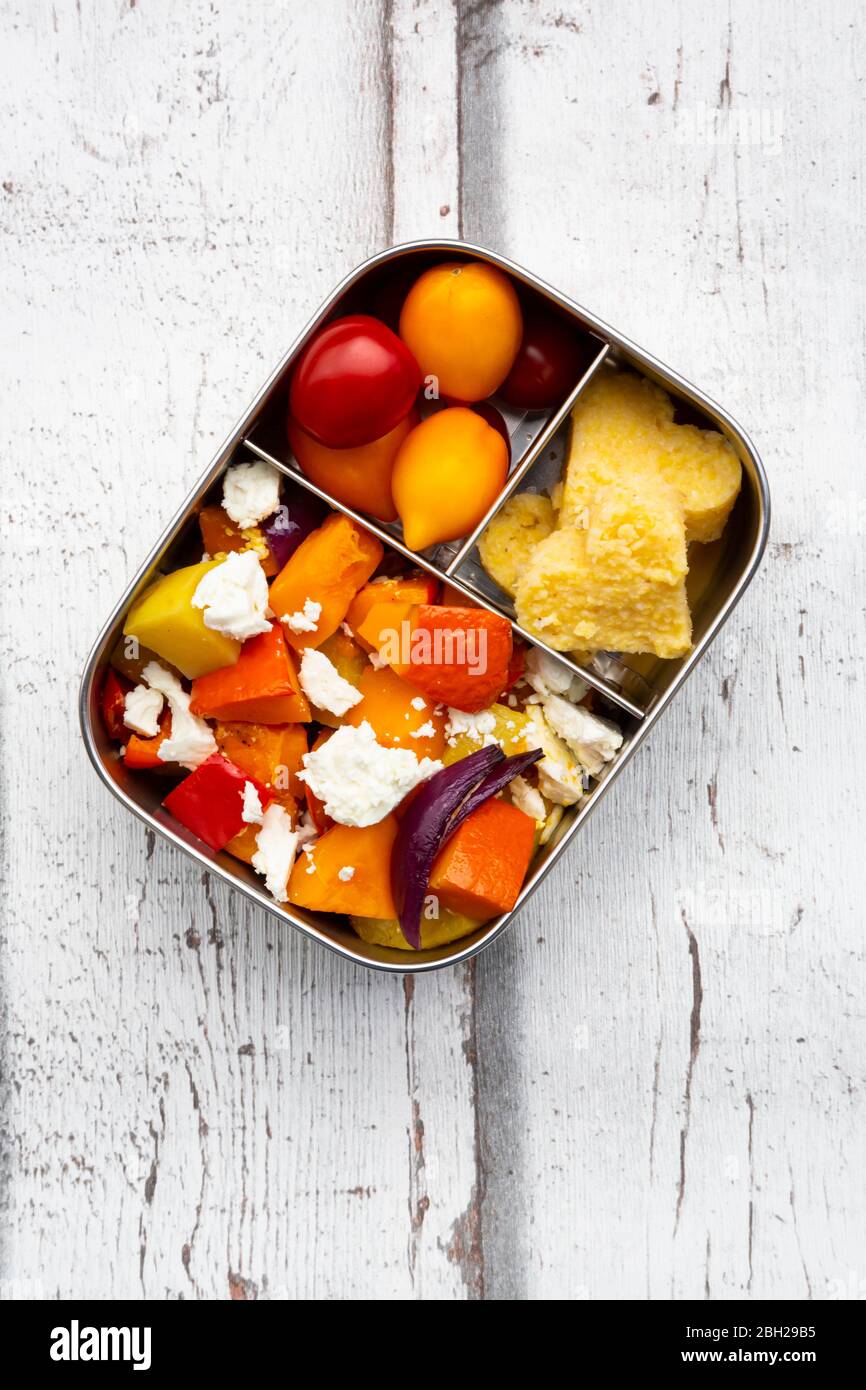 Lunch box with autumn oven baked vegetables, feta cheese and heart shaped polenta Stock Photo