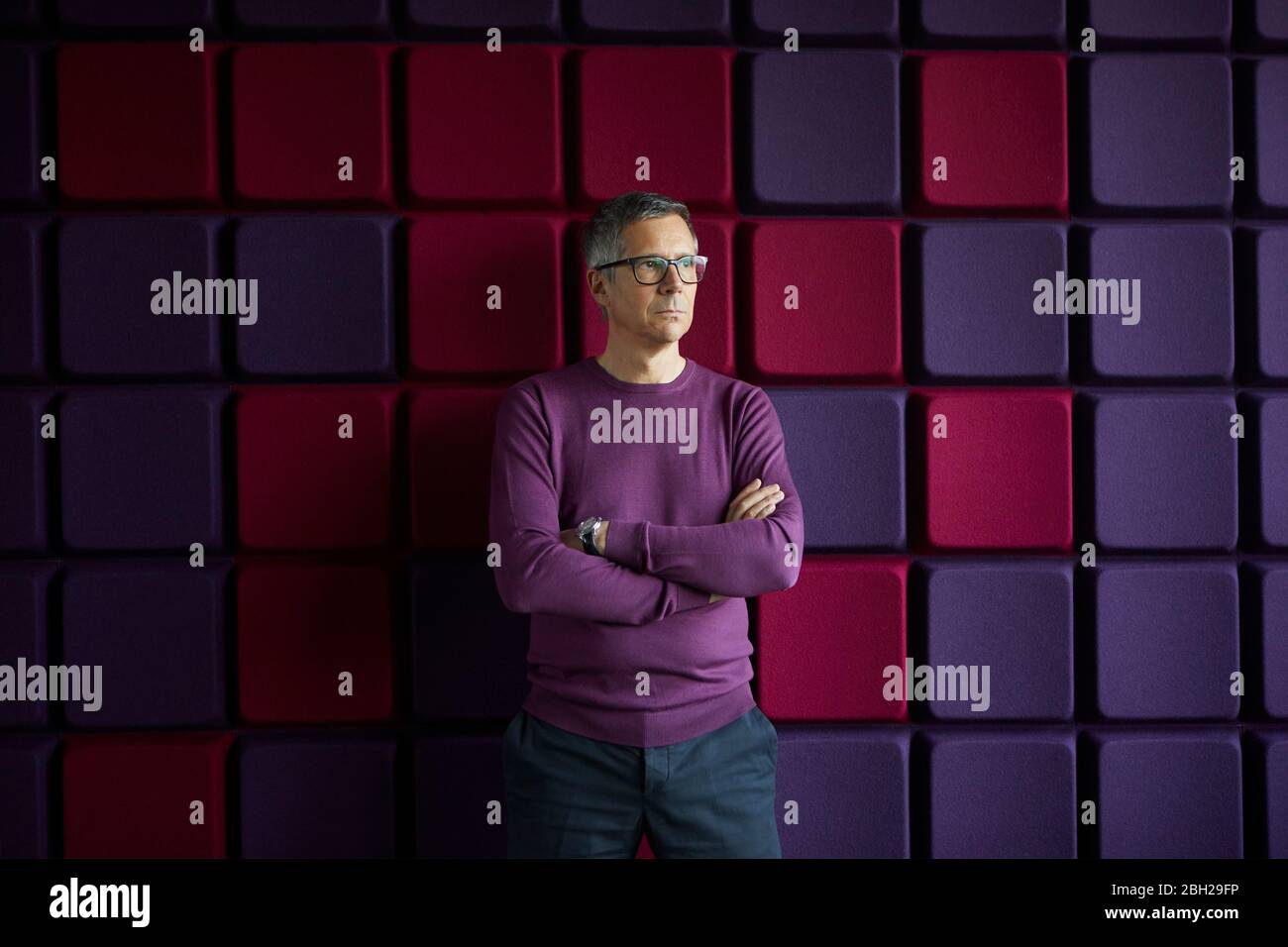 Businessman standing at a noise reduction wall in office Stock Photo