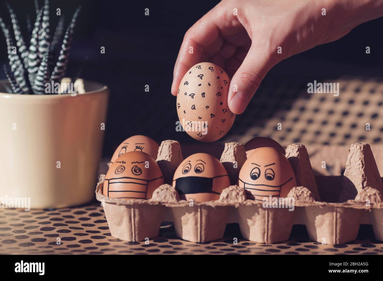 Easter eggs with face masks in a cardboard box Stock Photo