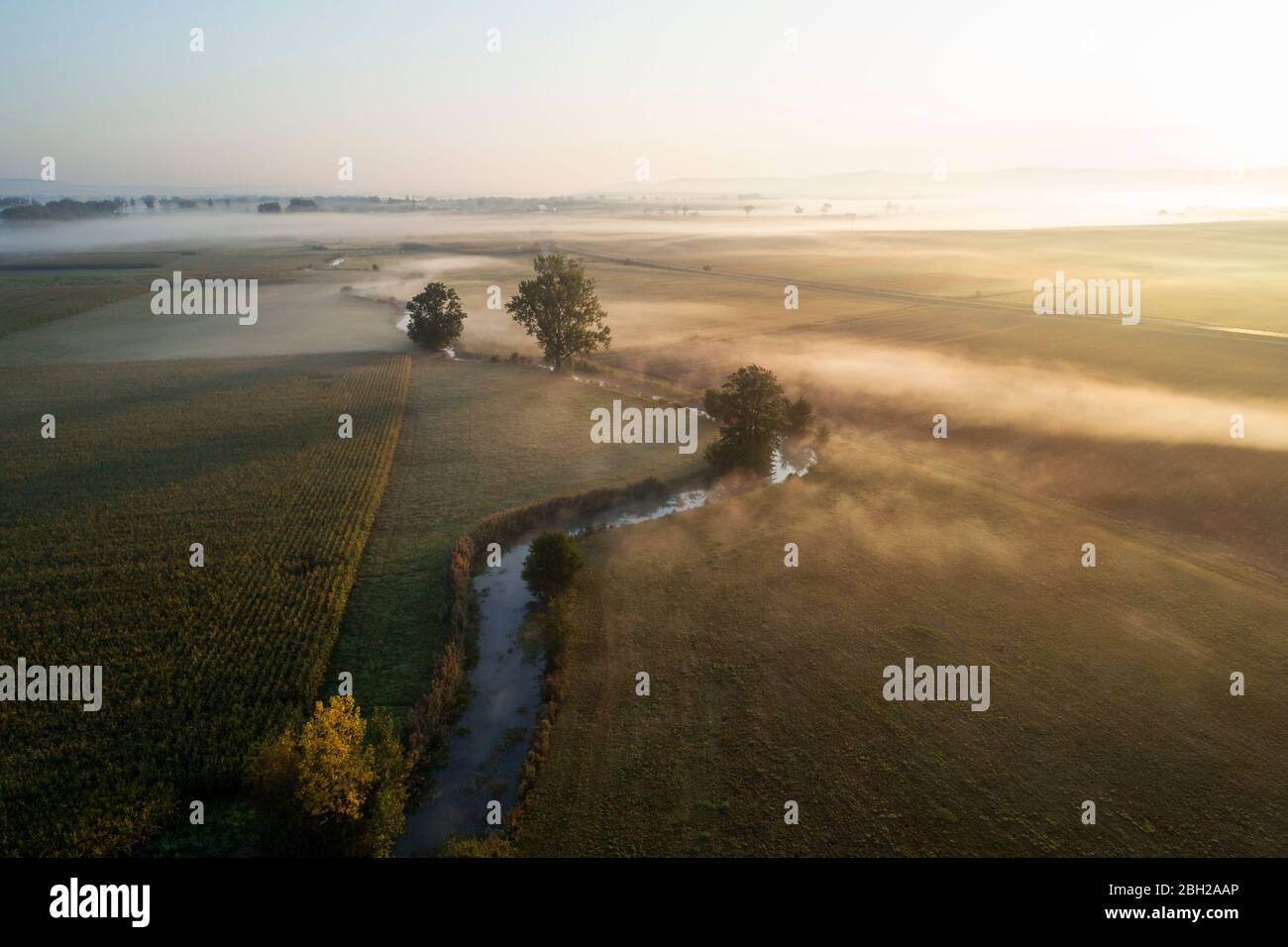 Germany, Bavaria, Drone view of river Aisch and surrounding countryside landscape at foggy sunrise Stock Photo