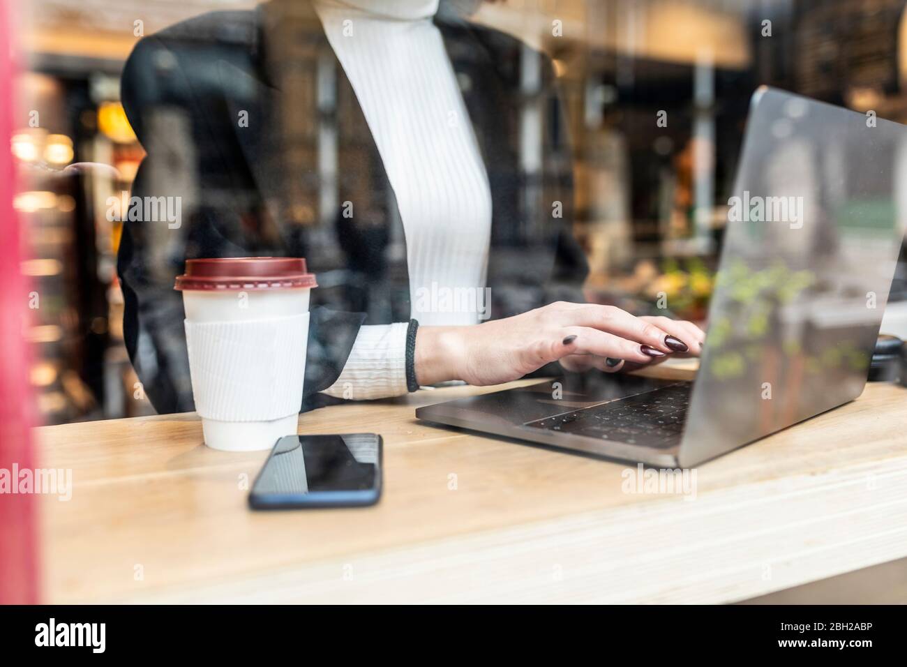 Close-up of businesswoman using laptop at a cafe in the city Stock Photo