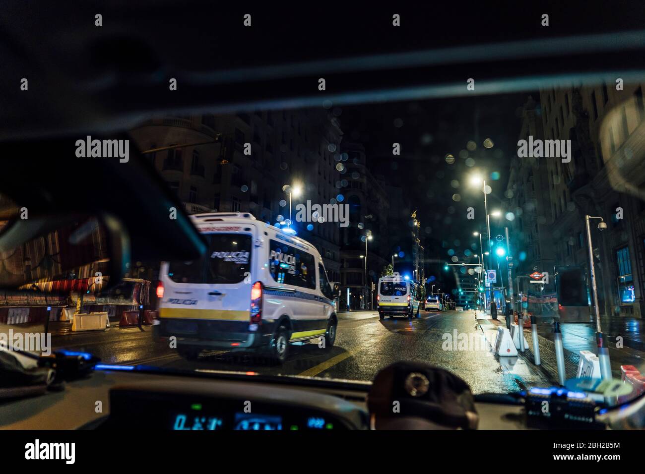 Spain, Madrid, Interior of car driving behind police at night Stock Photo