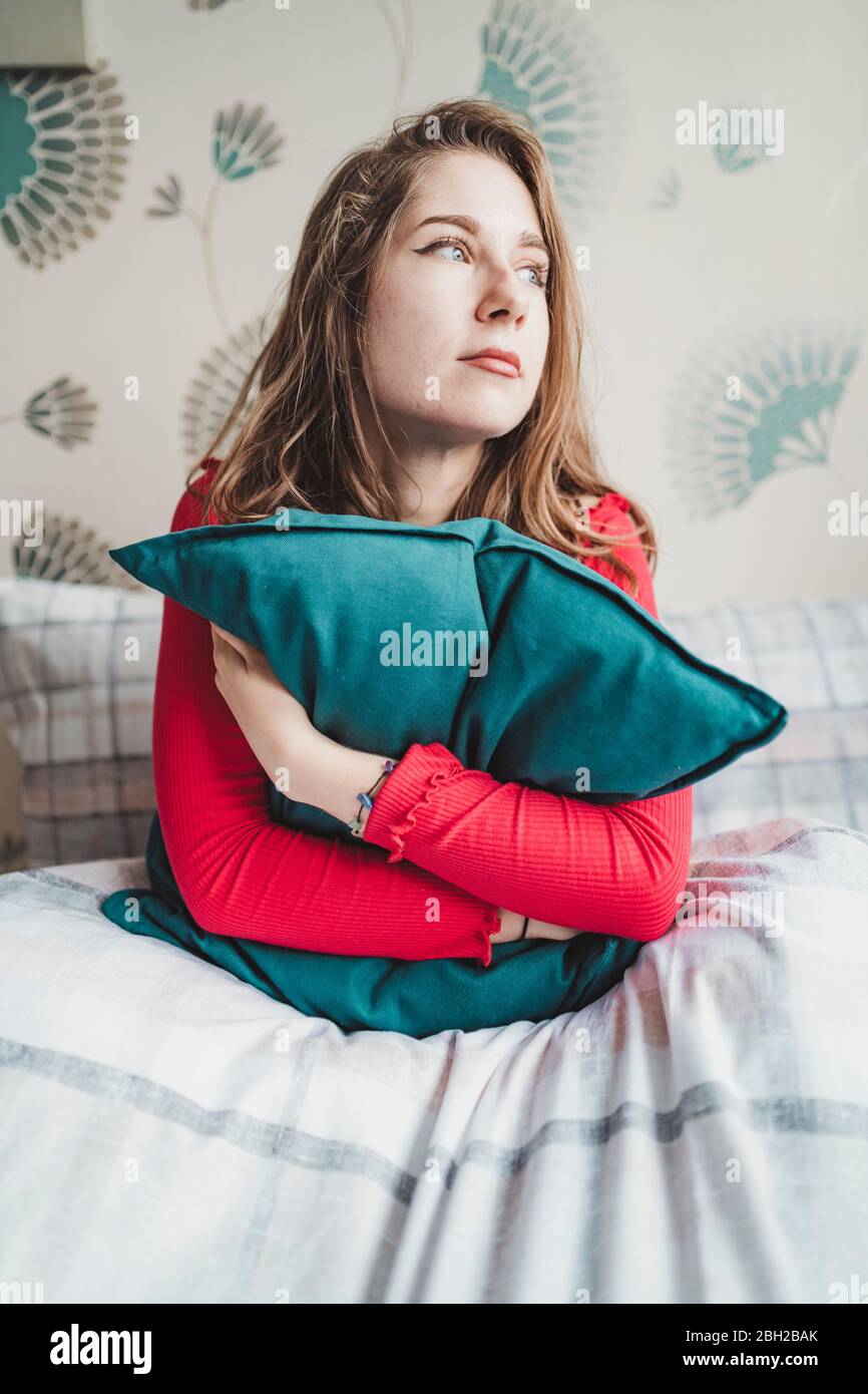 Young Woman Sitting In Bed With Heart Shaped Cushion High-Res Stock Photo -  Getty Images