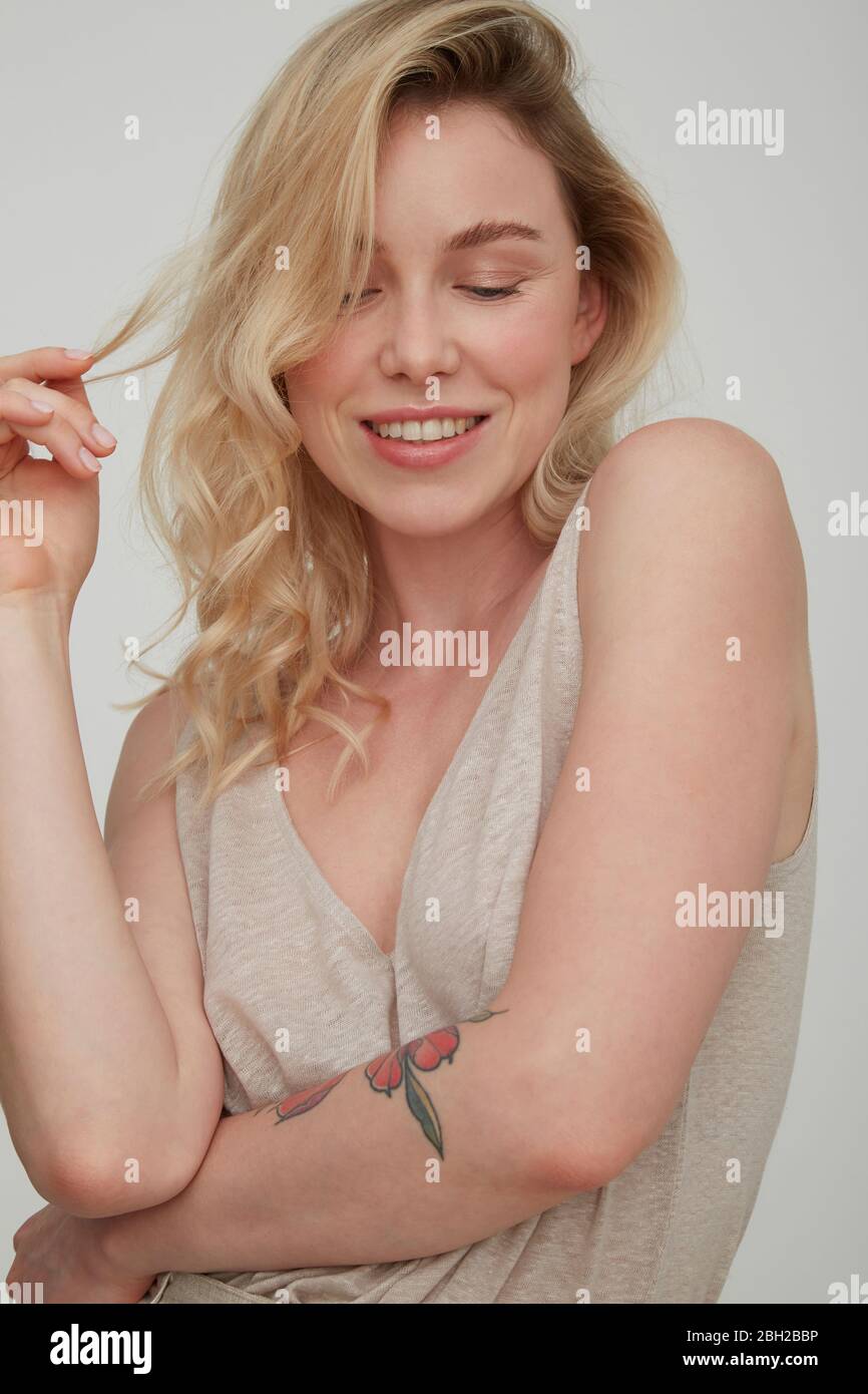 Portrait of smiling blond young woman with tattoo Stock Photo