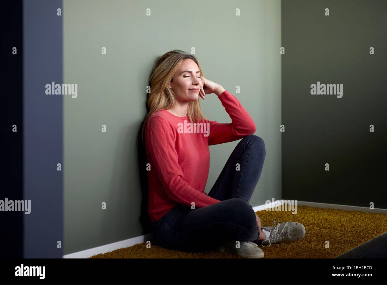 Relaxed woman with closed eyes sitting on the floor Stock Photo - Alamy