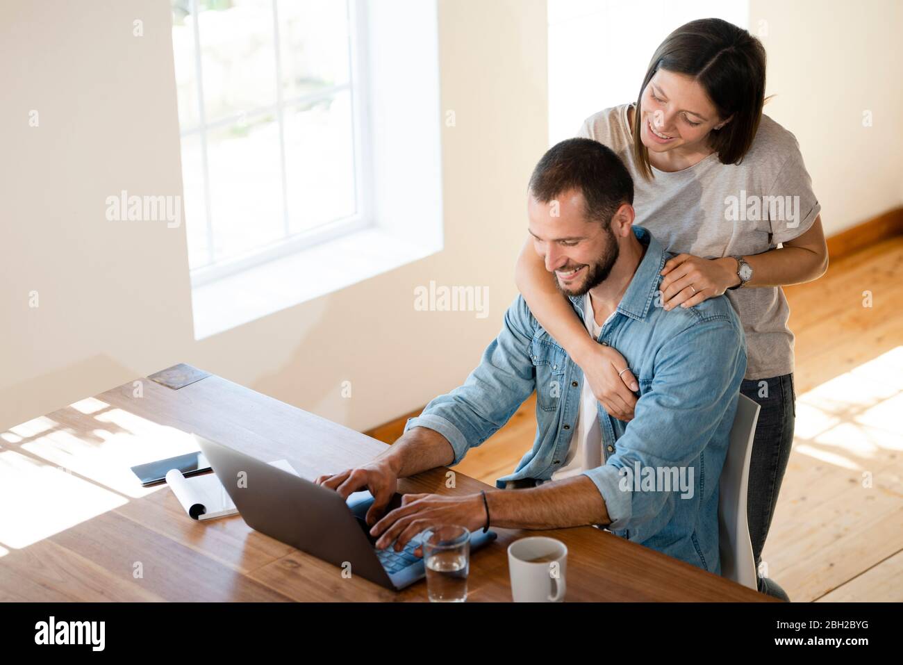Happy young couple using laptop at home Stock Photo