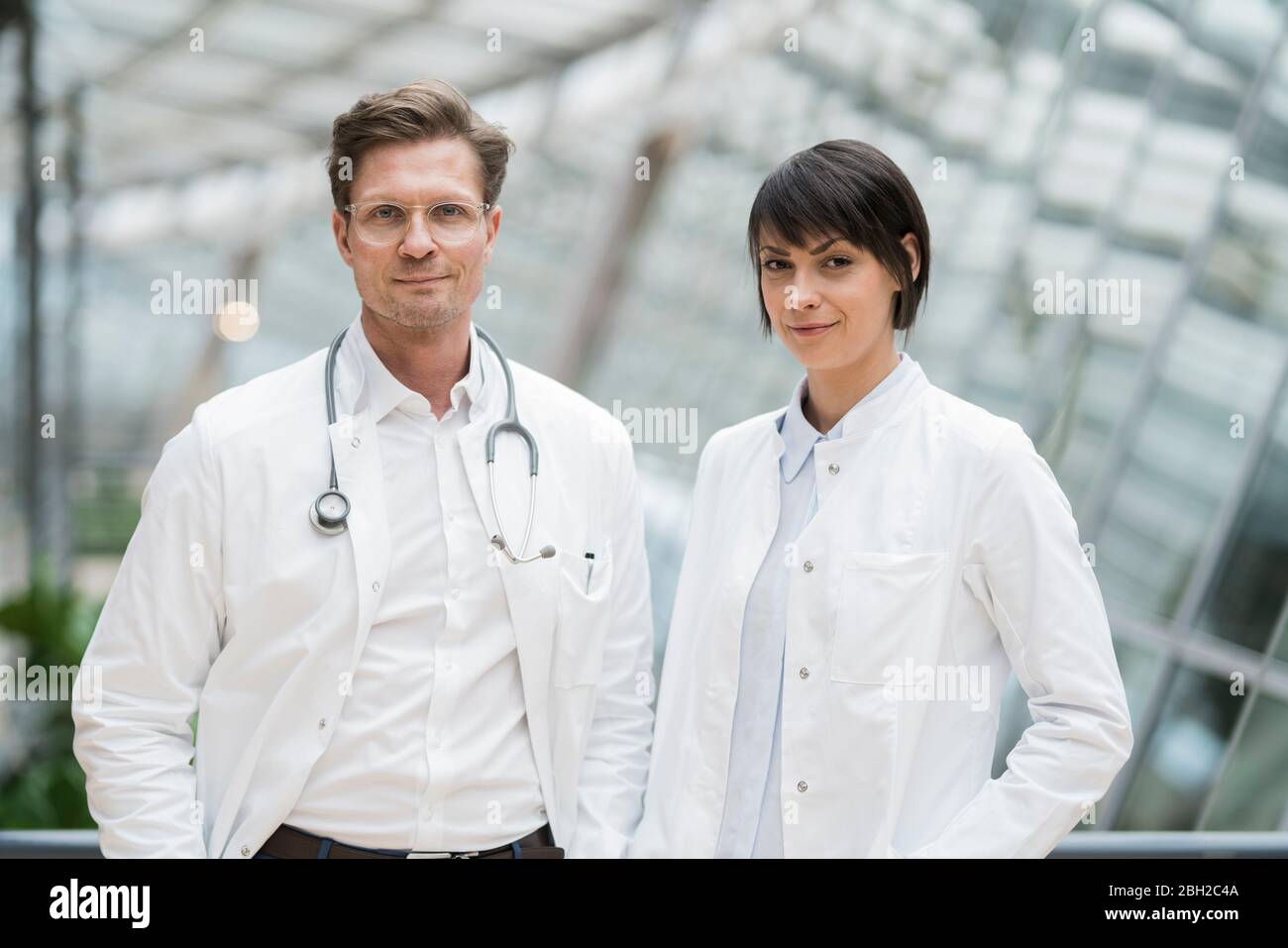 Two confident doctors standing in atrium Stock Photo