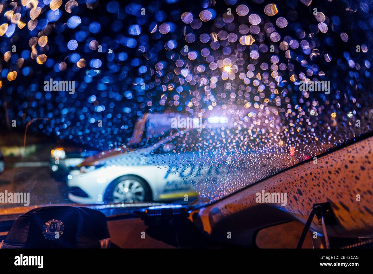 Spain, Madrid, Interior of car parked in front of patrolling police car at night Stock Photo