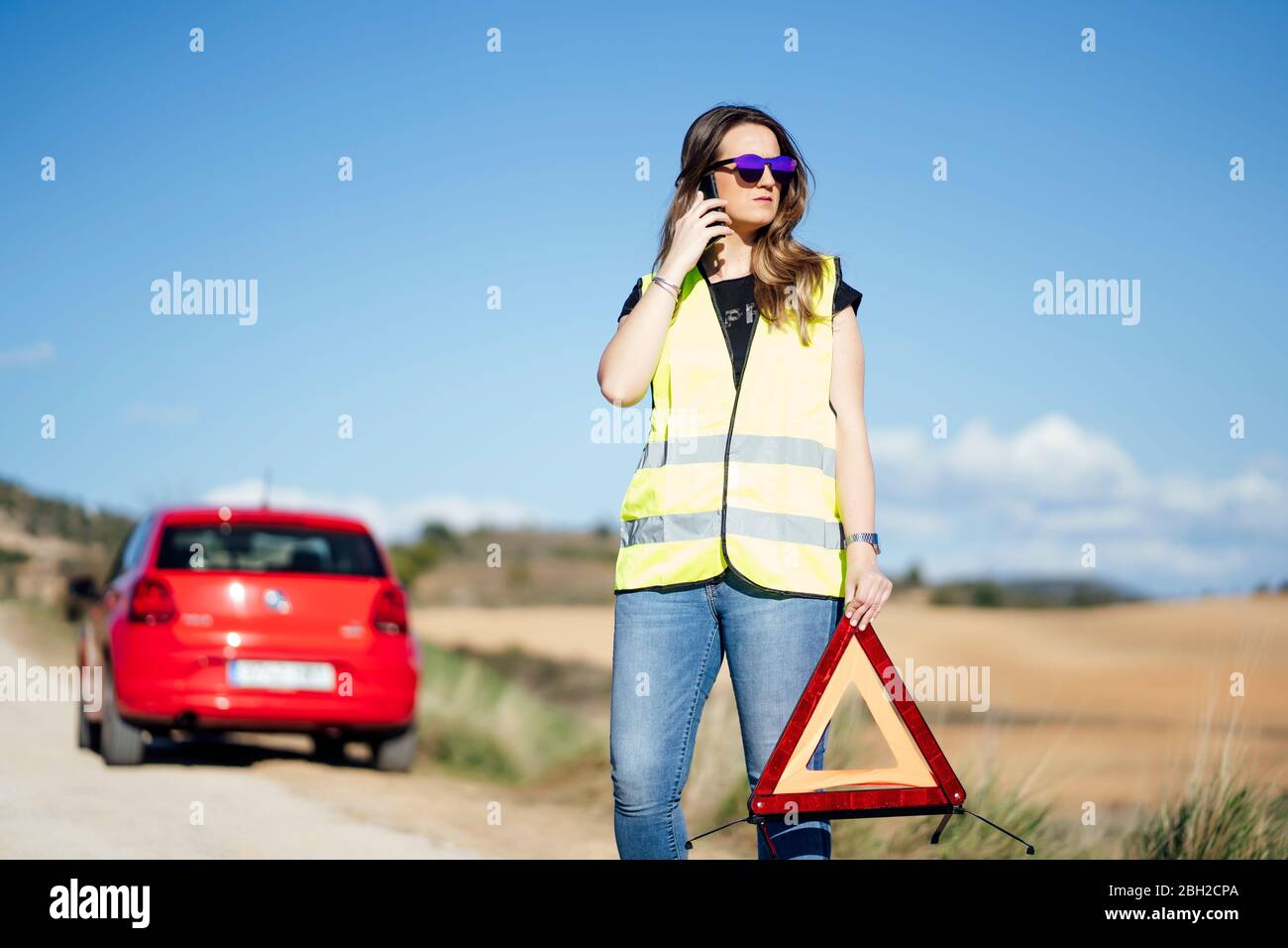 Woman having a breakdown in the countryside talking on the phone Stock Photo