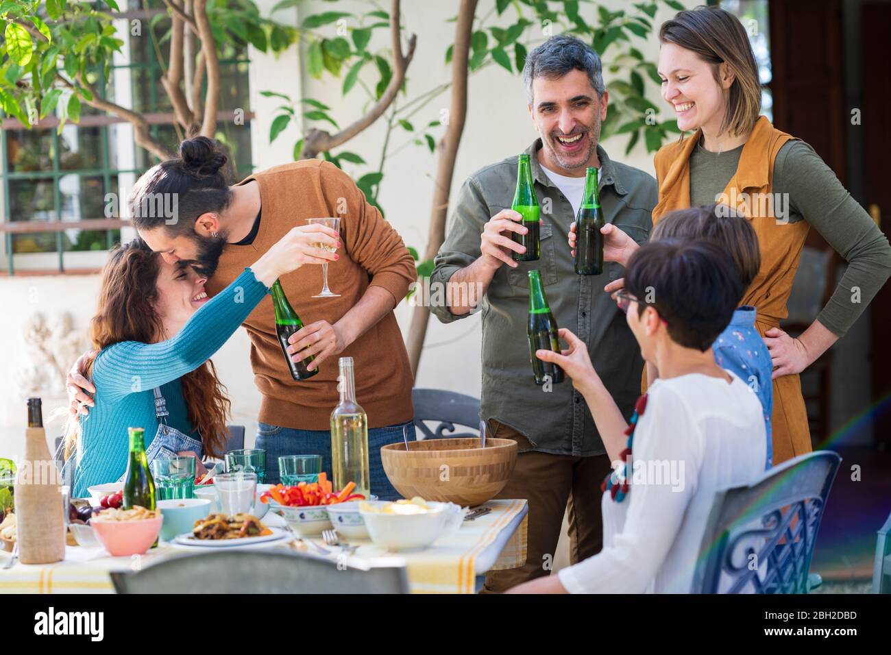 Happy friends enjoying lunch in the countryside, drinking wine and beer Stock Photo