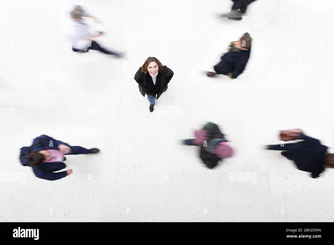 Portrait of woman amidst moving people Stock Photo