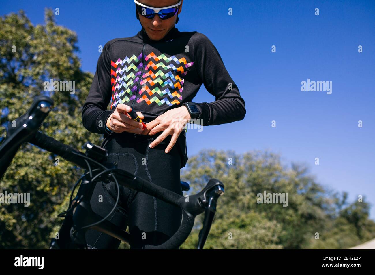 Diabetic cyclist injecting insulin before starting his ride Stock Photo