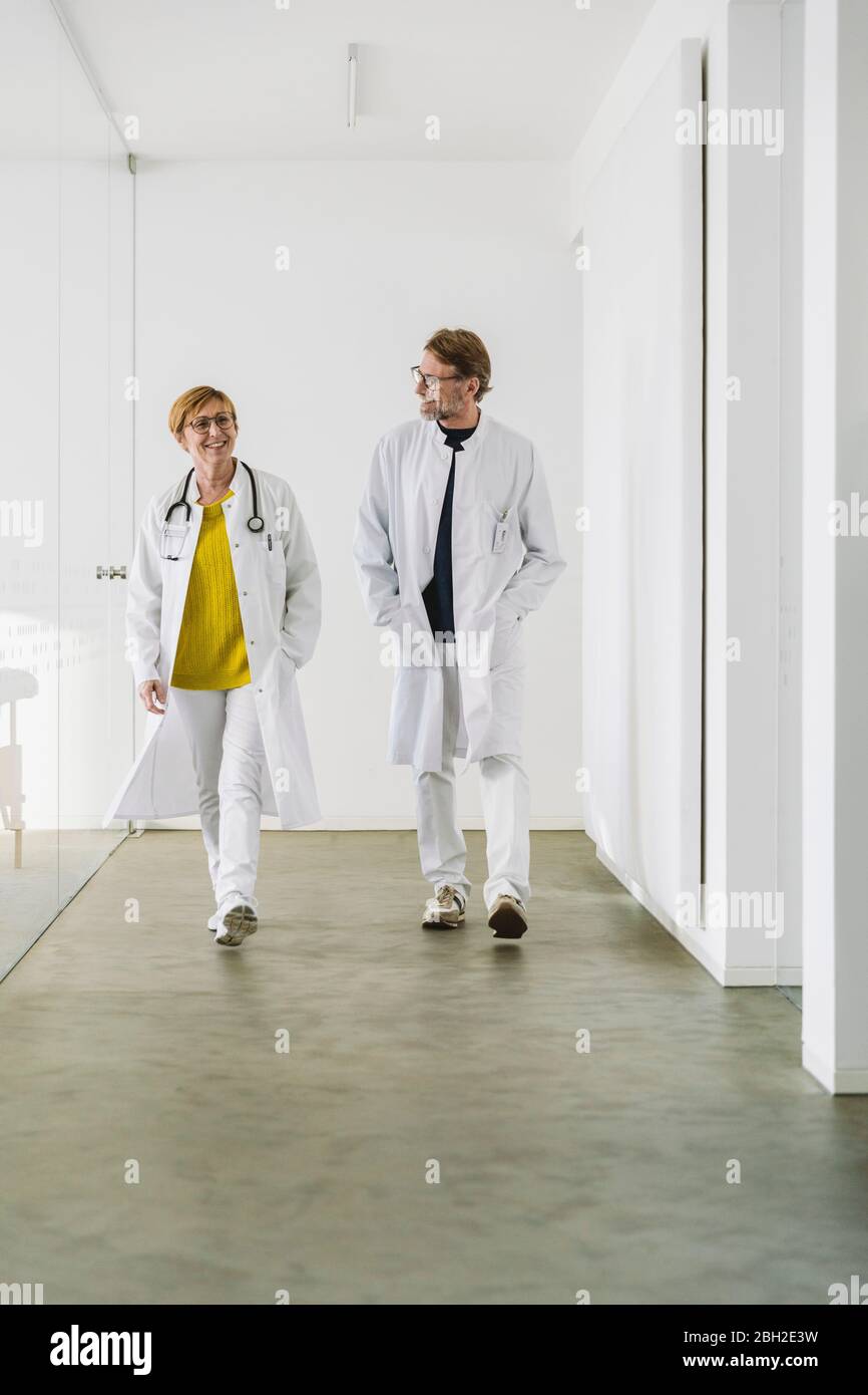 Two doctors waking along hallway Stock Photo
