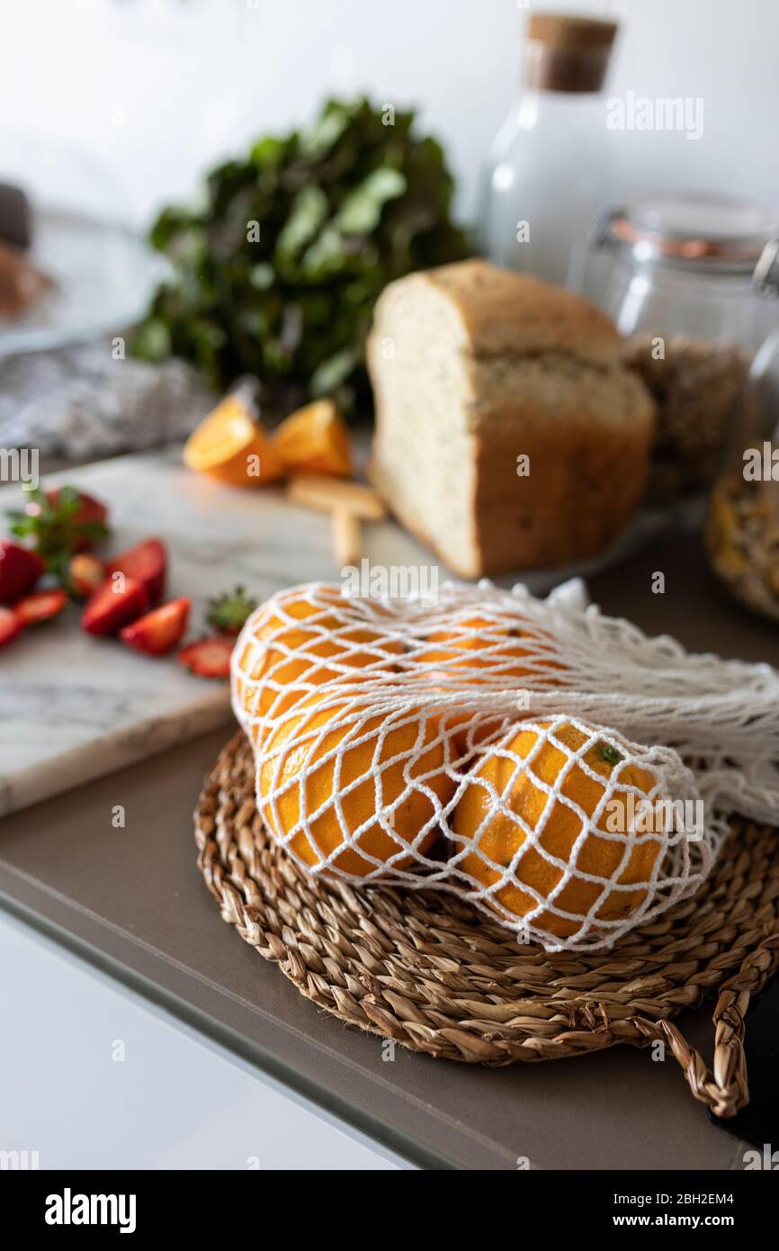 Oranges in net on kitchen counter Stock Photo
