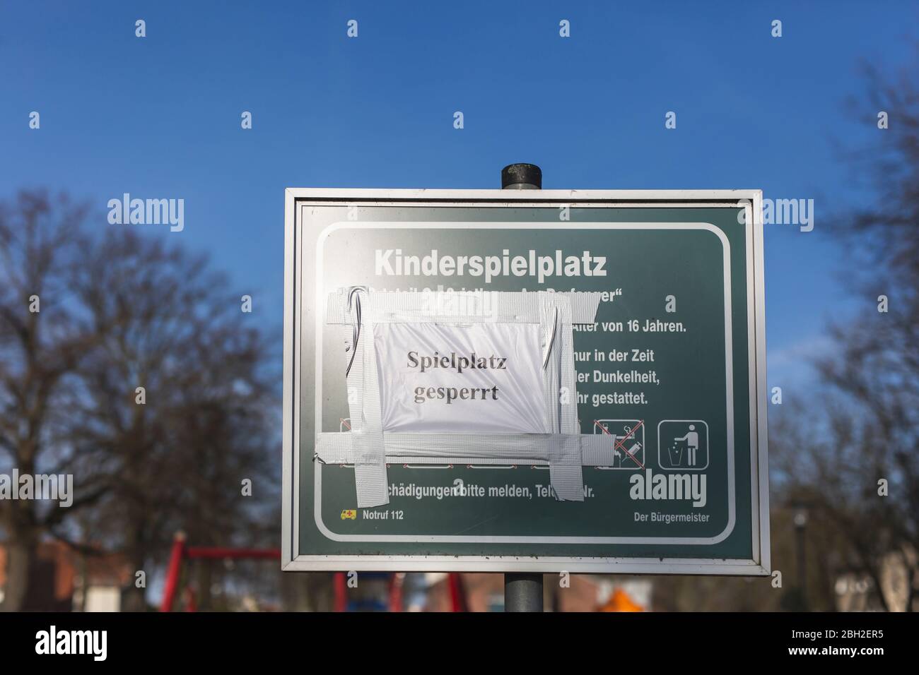 Germany, Brandenburg, Playground closed message taped on playground information sign during COVID-19 epidemic Stock Photo