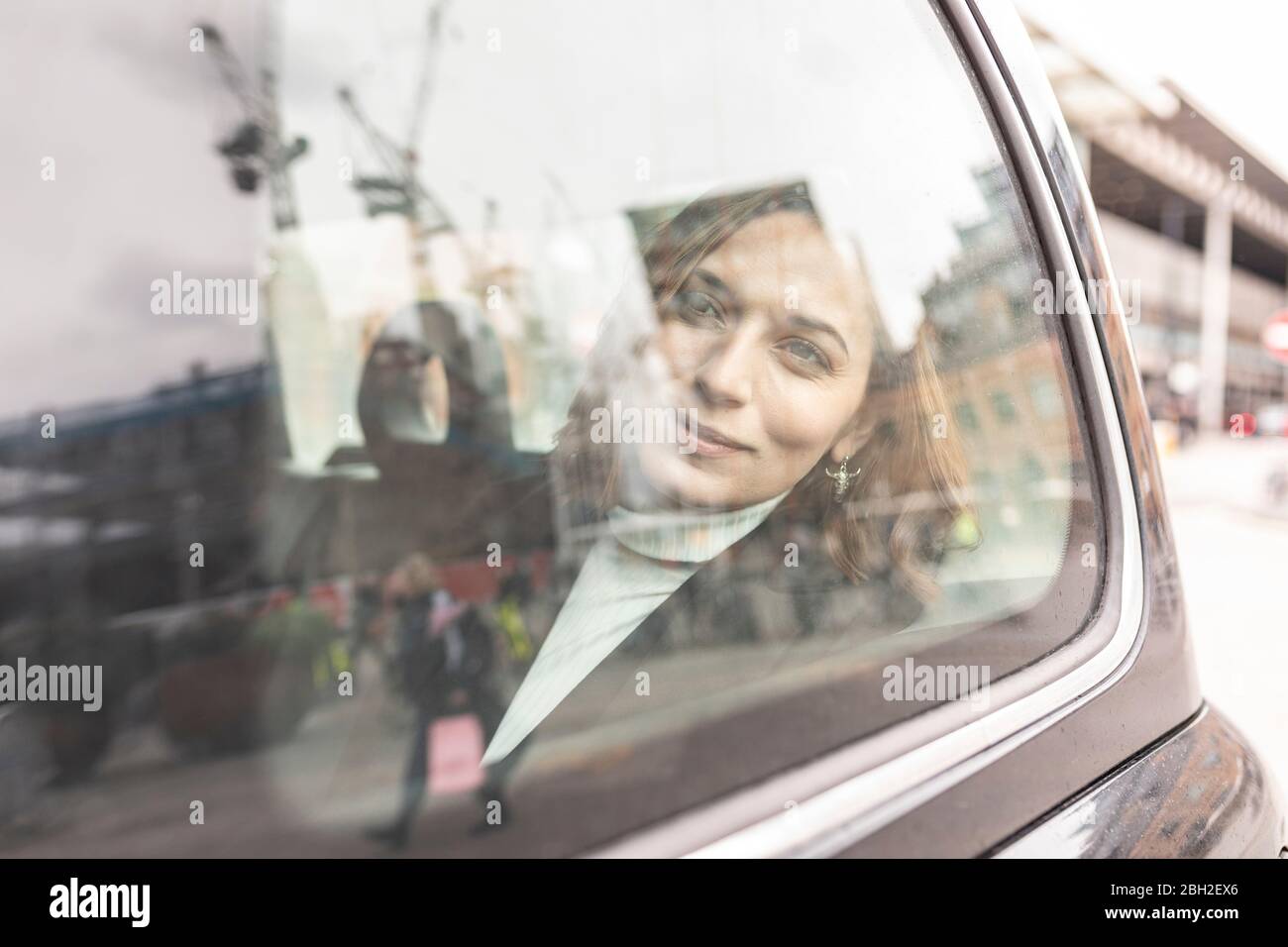 Woman in the rear of a taxi looking out of the window, London, UK Stock Photo