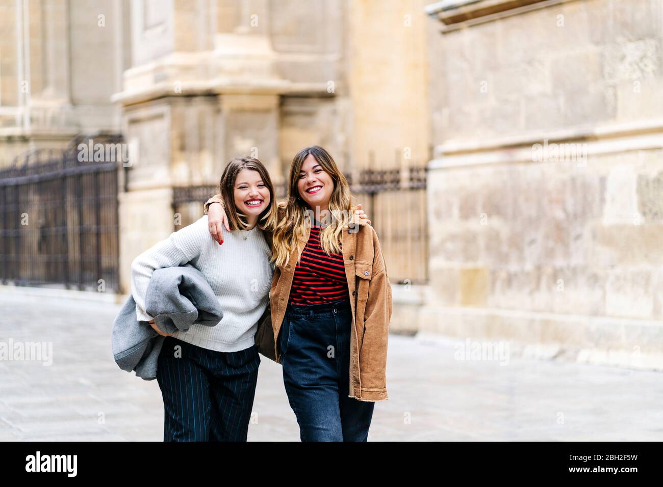 Two young women walking arm hi-res stock photography and images - Alamy