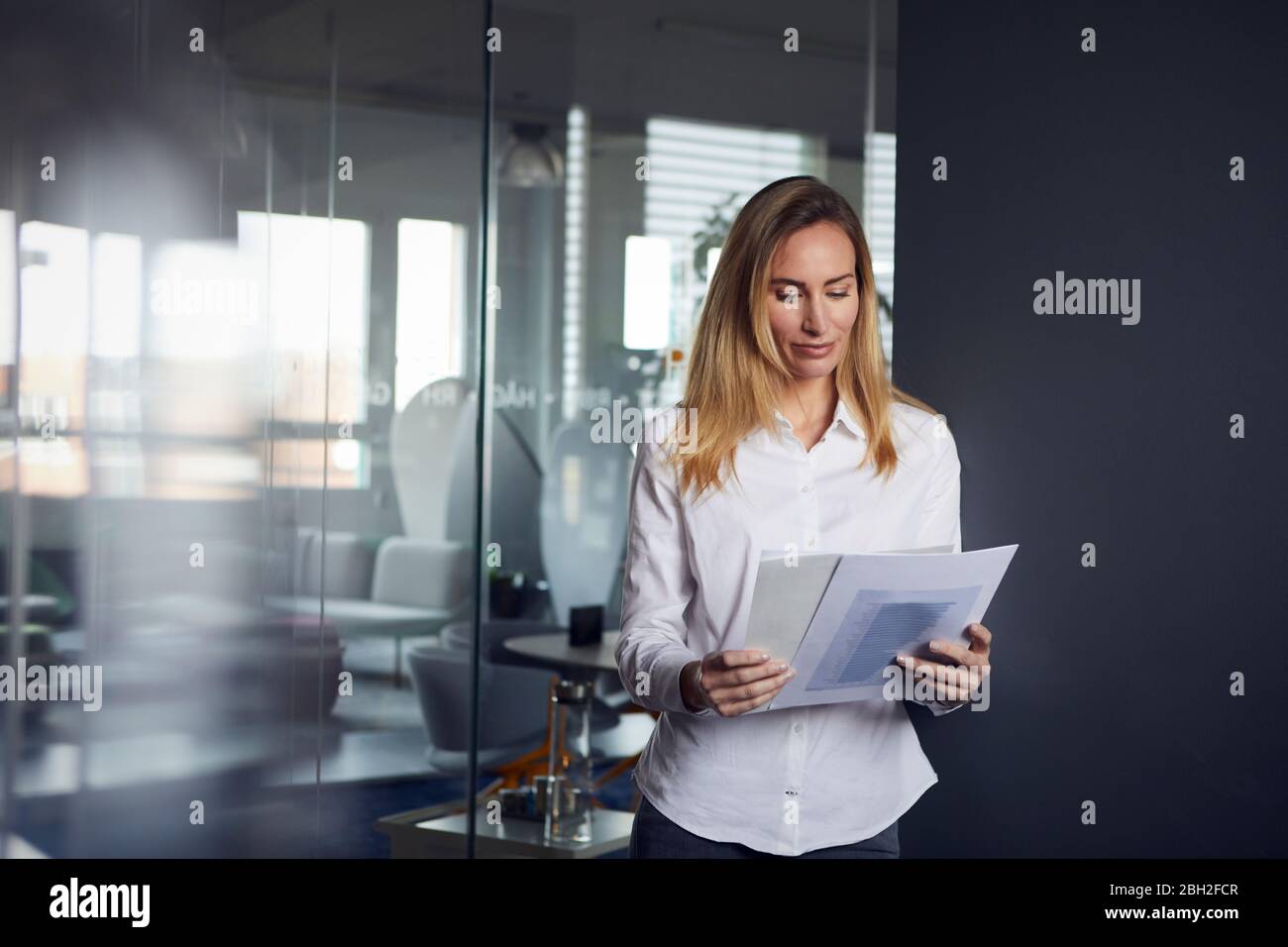 Portait of businesswoman reviewing papers in office Stock Photo
