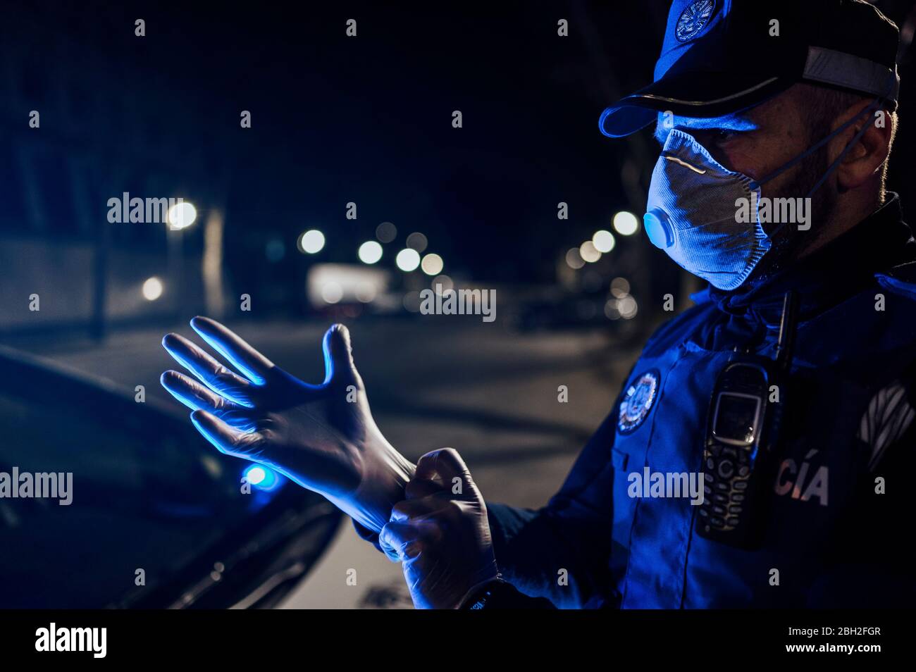 Portrait of policeman wearing mask and protective gloveat night Stock Photo