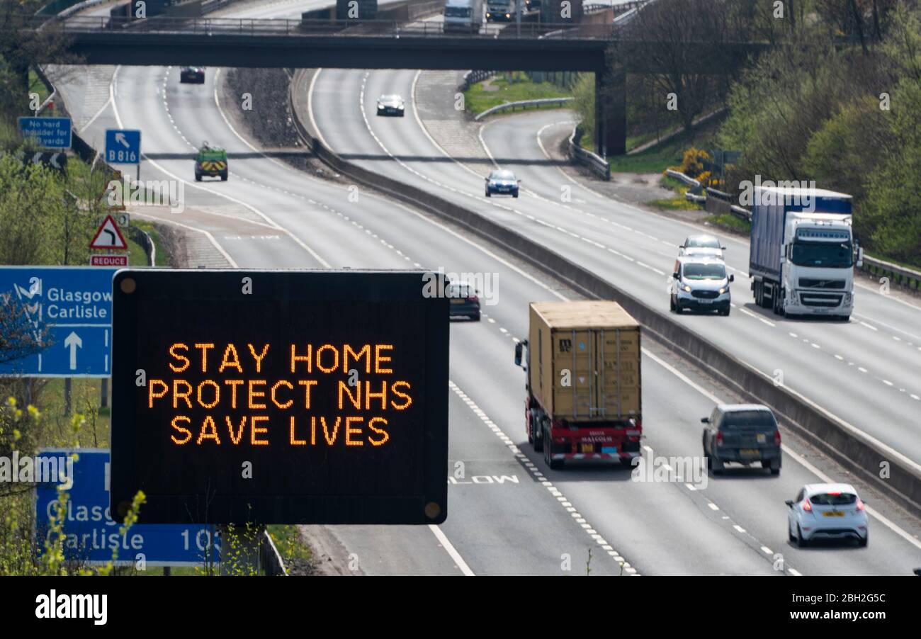 Castlecary, Scotland, UK. 23 April 2020. Overhead warning sign on M80 motorway advising motorists to stay home to protect the NHS during the coronavirus lockdown in the UK. Traffic volumes on the motorway remain very low.  Iain Masterton/Alamy Live News Stock Photo