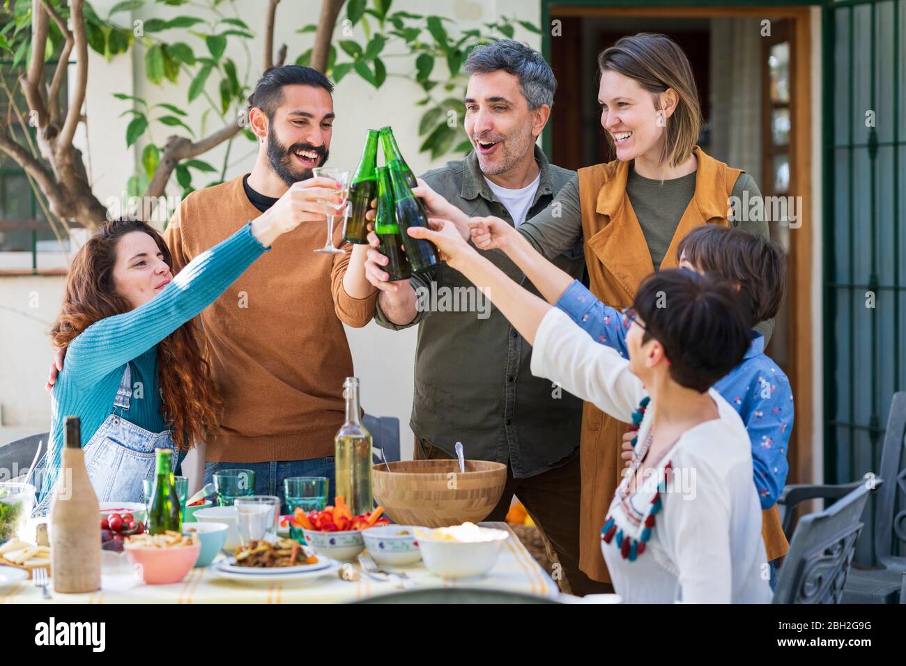 Happy friends enjoying lunch in the countryside, drinking wine and beer Stock Photo