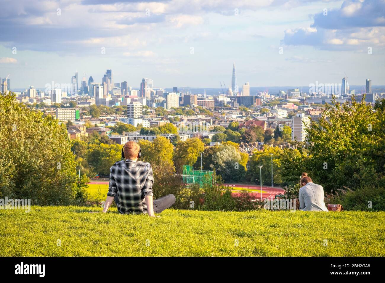 Back view of tourists looking over London city skyline from Parliament Hill in Hampstead Heath Stock Photo