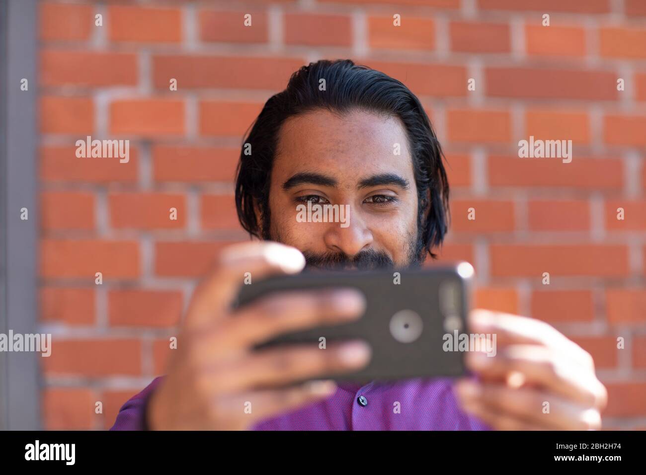 Young man taking a selfie with his smartphone Stock Photo