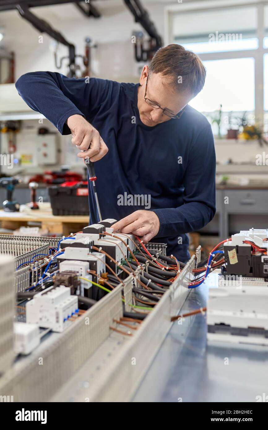 Electrician working on circuitry in workshop Stock Photo
