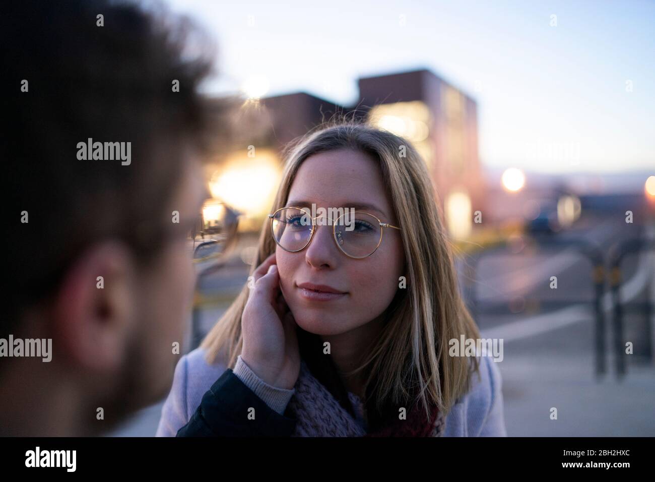 Portrait of blond young woman face to face with her boyfriend at evening twilight Stock Photo