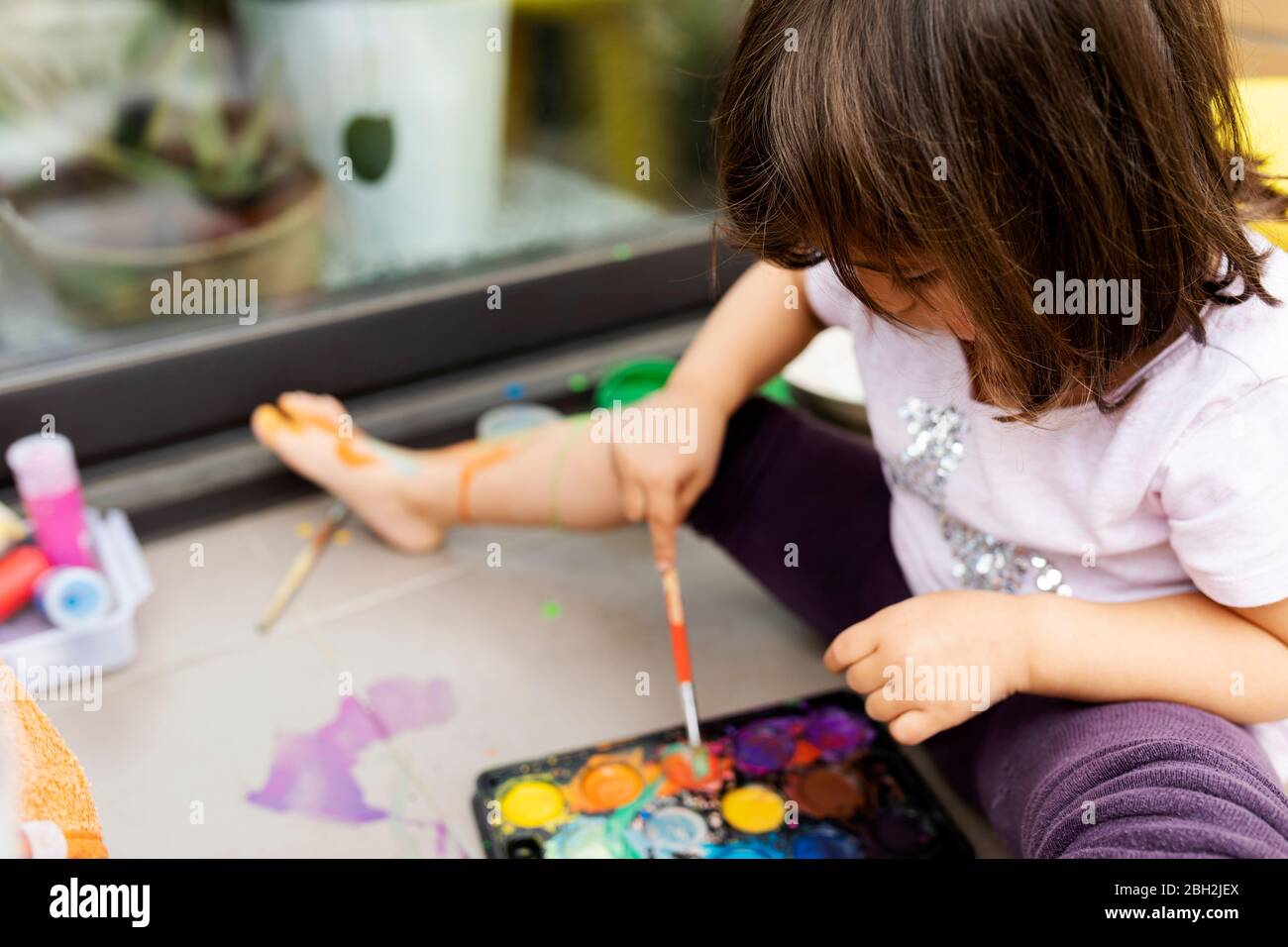 Little girl painting with watercolors Stock Photo - Alamy
