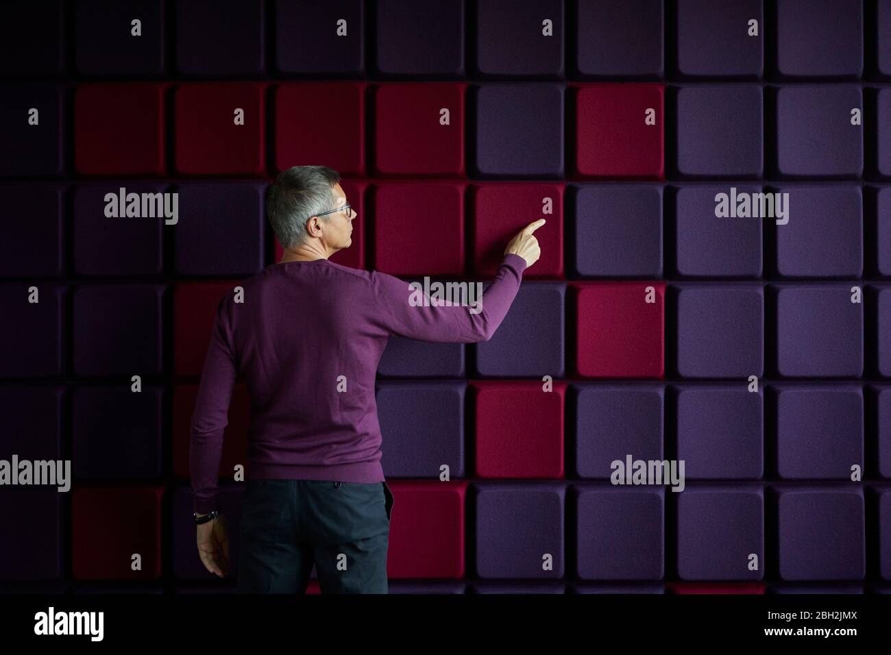 Businessman touching noise reduction wall in office Stock Photo