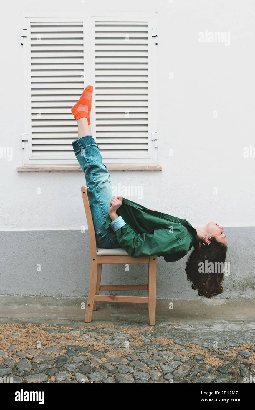 Young woman with eyes closed lying on a chair outdoors Stock Photo - Alamy