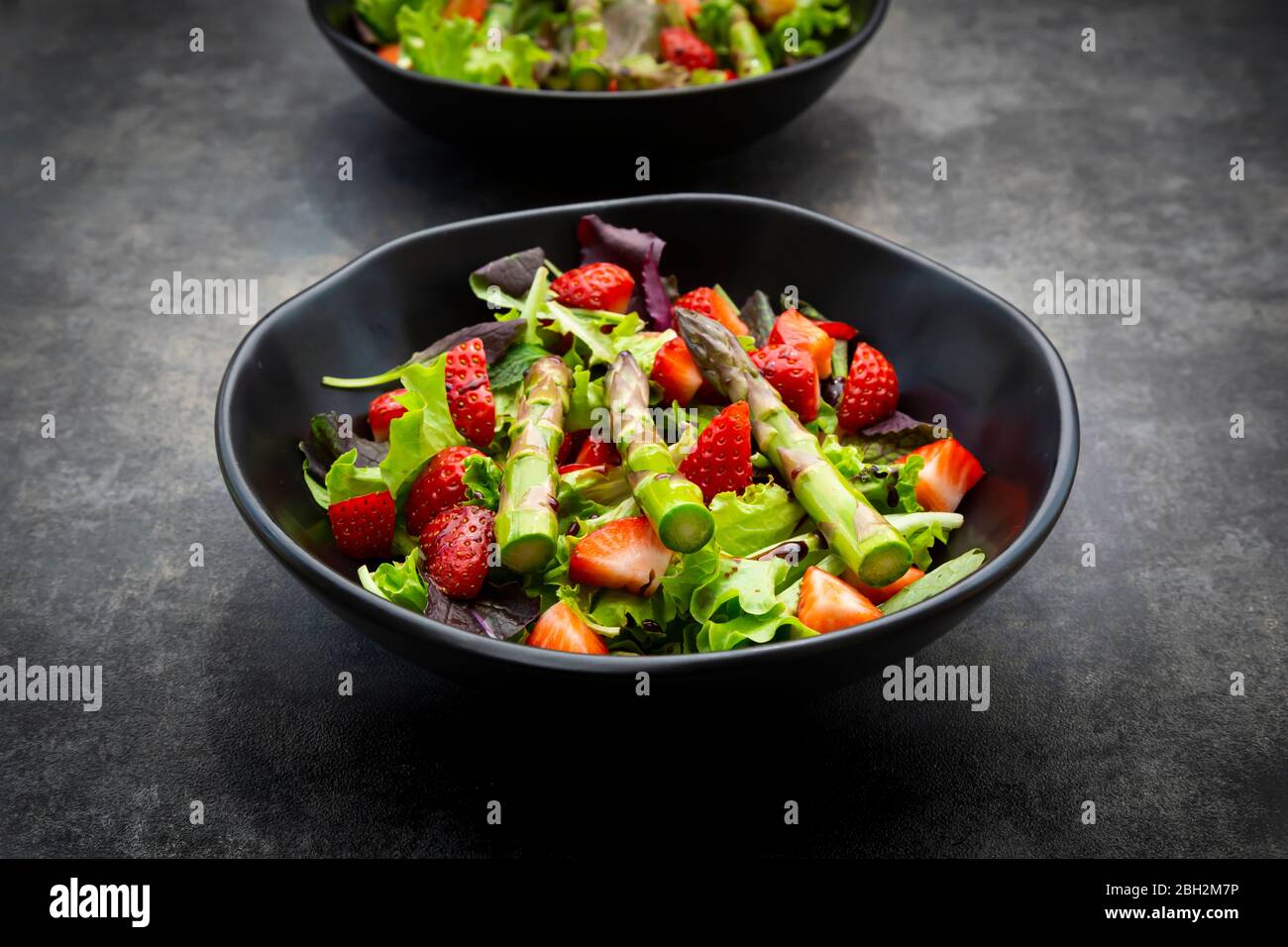 Bowl of vegetarian salad with lettuce, strawberries and asparagus Stock Photo