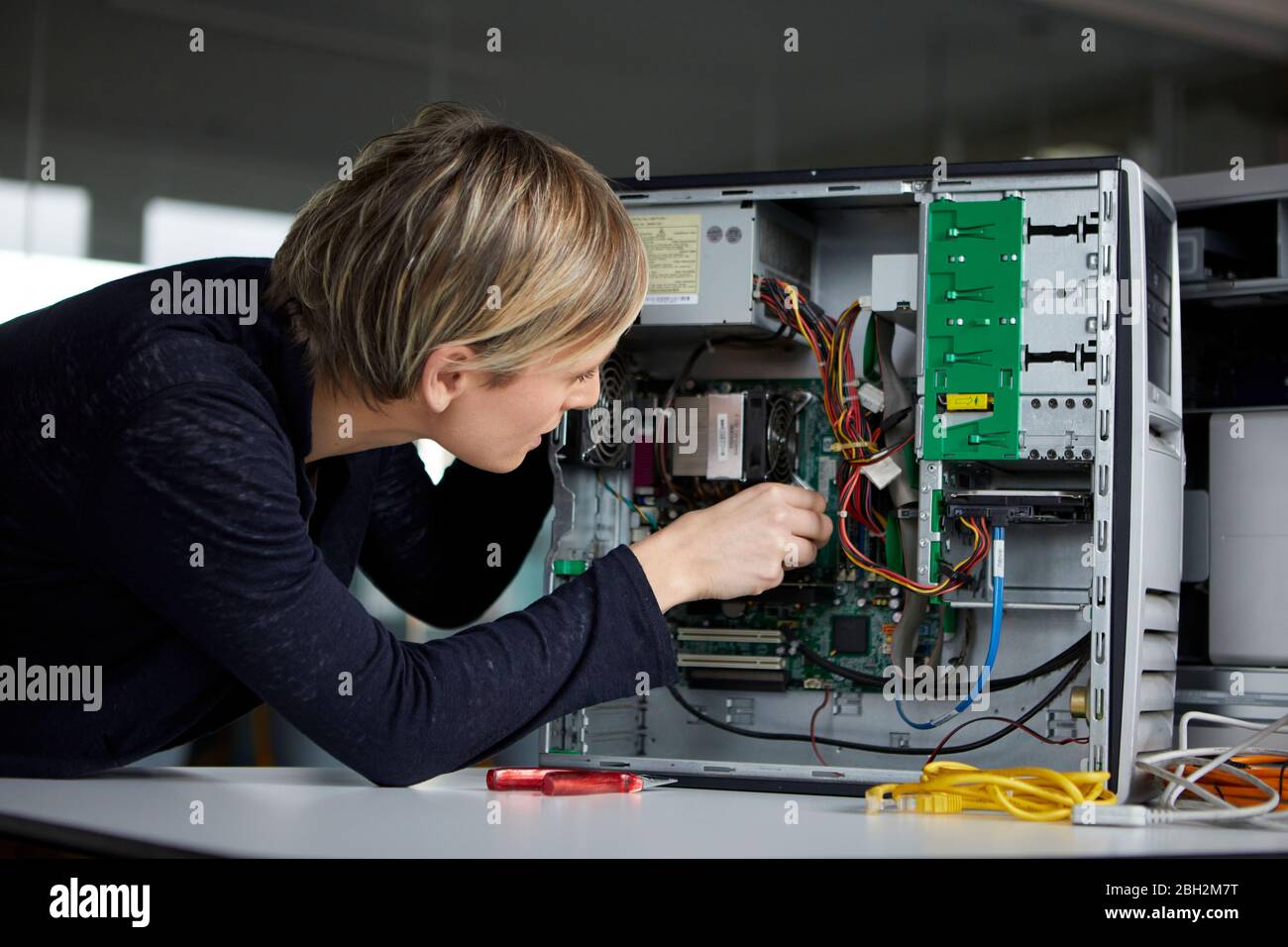 Woman assembling desktop pc in office Stock Photo