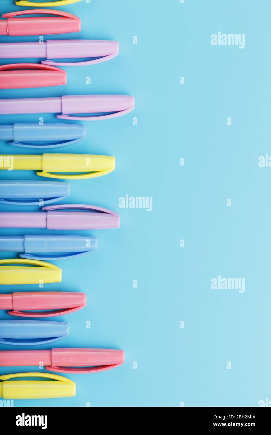 Multi-colored markers on a blue background with free space. Stock Photo