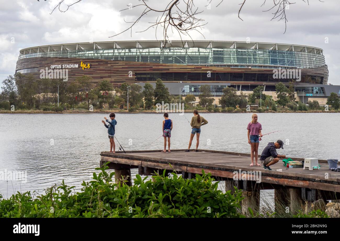 Father and children fishing off a wooden jetty on the Swan River and ...