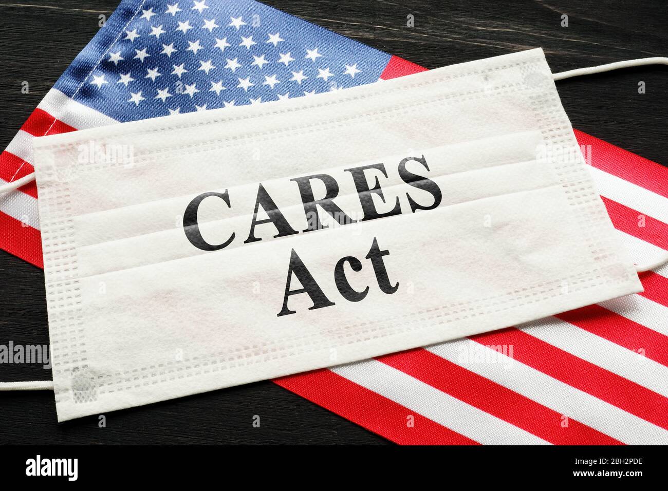 American flag and mask with sign cares act. Coronavirus Aid, Relief, and Economic Security law concept. Stock Photo