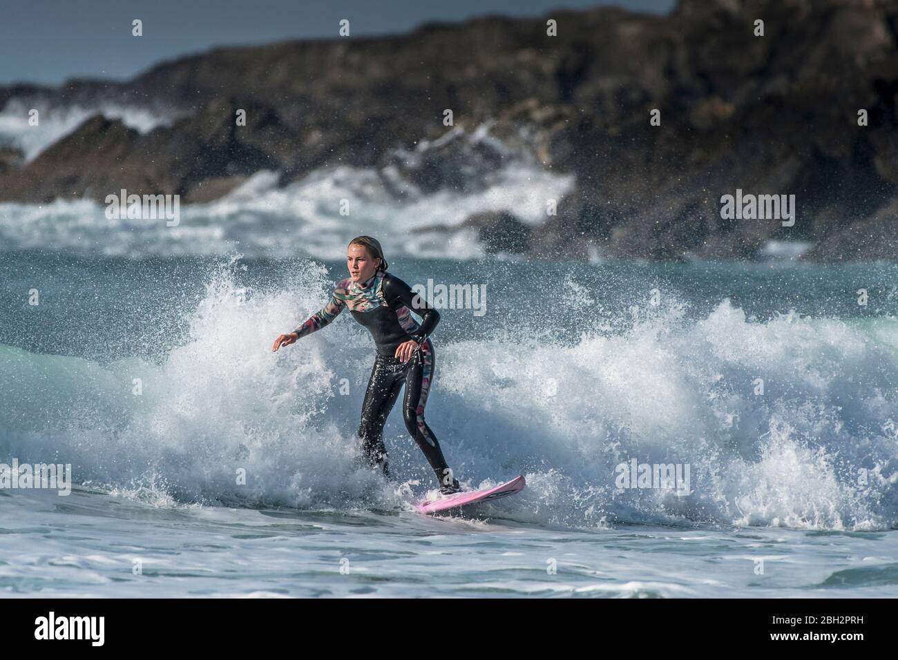 A female teenage surfer in surfing action at Fistral in Newquay in Cornwall. Stock Photo