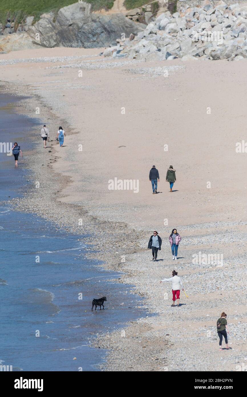 People walking on Fistral Beach in Cornwall and maintaining social distancing due to the Coronavirus Covid 19 pandemic. Stock Photo