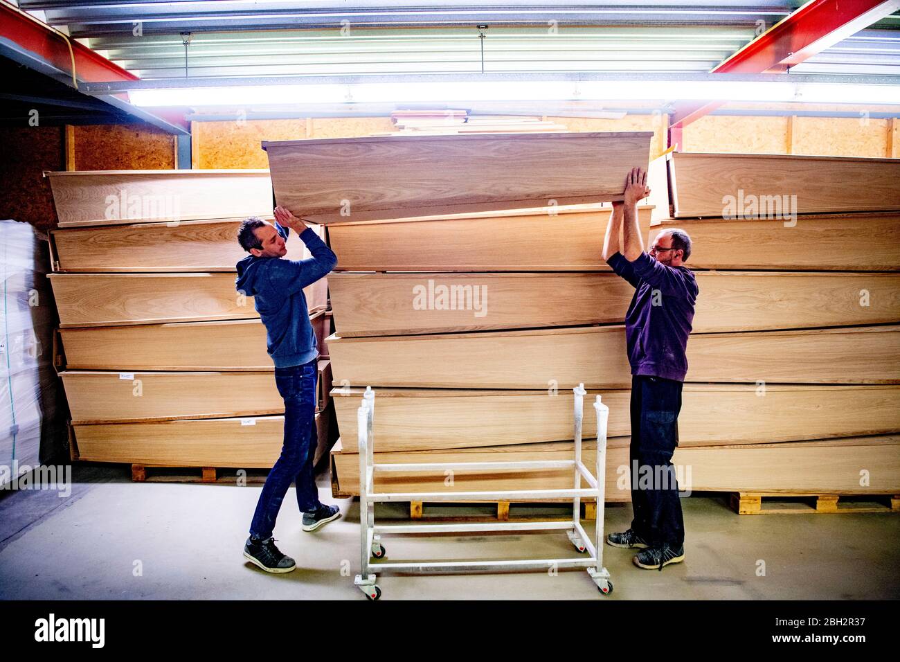 Gendringe, Netherlands. 23rd Apr, 2020. Employees carrying a casket at Tomba coffin maker.As the Coronavirus pandemic ravages Netherlands one coffin design firm south of Gendering has been busy delivering hundreds of caskets per week to double the usual production capacity. Coffin makers and the funeral industry at large are working hard. Credit: SOPA Images Limited/Alamy Live News Stock Photo