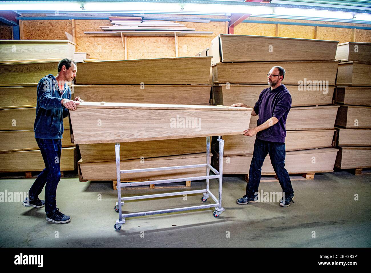 Gendringe, Netherlands. 23rd Apr, 2020. Employees pushing a casket at Tomba coffin maker.As the Coronavirus pandemic ravages Netherlands one coffin design firm south of Gendering has been busy delivering hundreds of caskets per week to double the usual production capacity. Coffin makers and the funeral industry at large are working hard. Credit: SOPA Images Limited/Alamy Live News Stock Photo