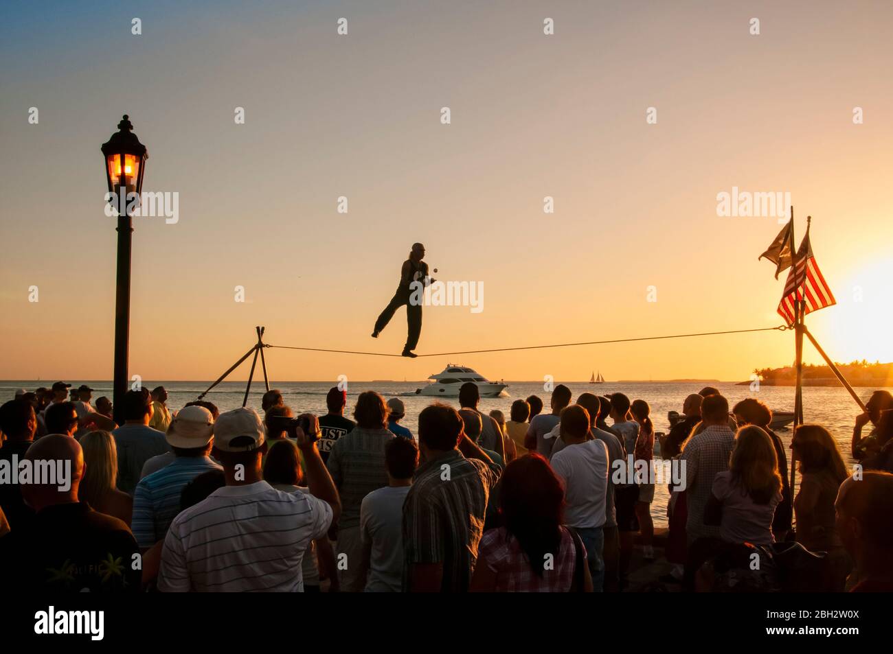 Show of an acrobat at sunset ocean front. Tourists watch the juggler in Key West Florida Stock Photo