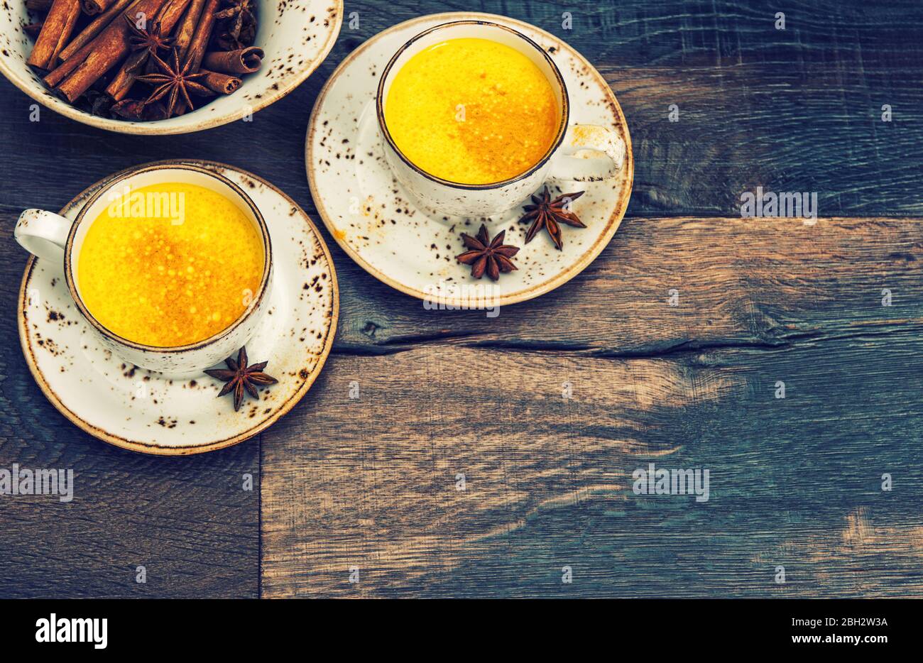 Hot curcuma turmeric milk drink with spices. Vintage style toned