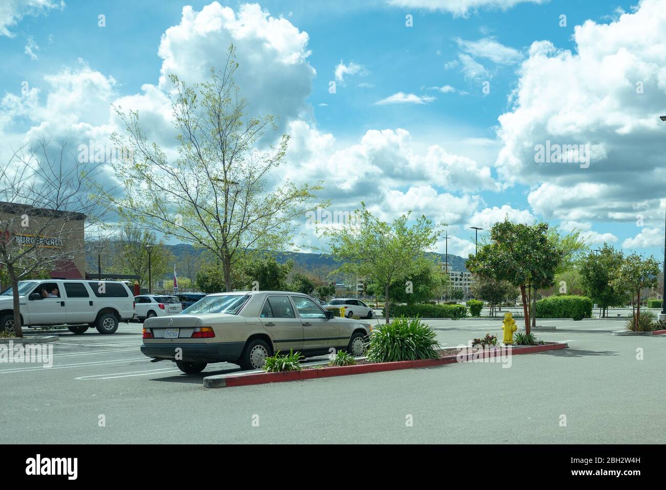 Cars are parked in a parking lot at Persimmon Place shopping center in