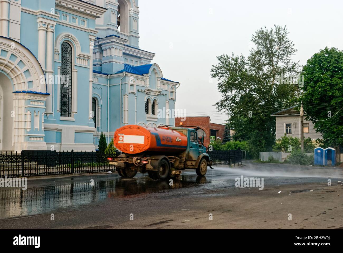 Kaluga Region, the city of Maloyaroslavets, Russia June 25, 2013: Street sprinkler in the early morning on the city street. Washes dirt off the road. Stock Photo