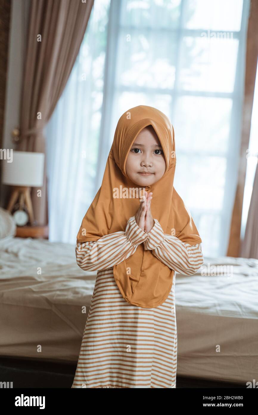 cute muslim girl greeting gesture welcoming ramadan Stock Photo